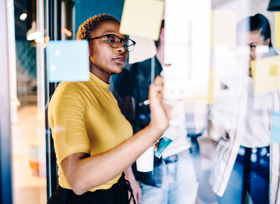 Woman writing ideas on a post-it