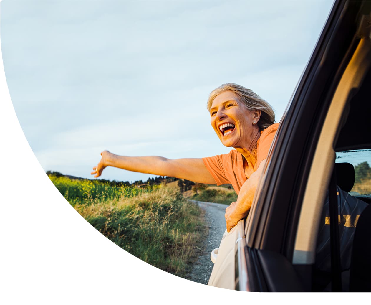 Woman with her head out the window of a moving car