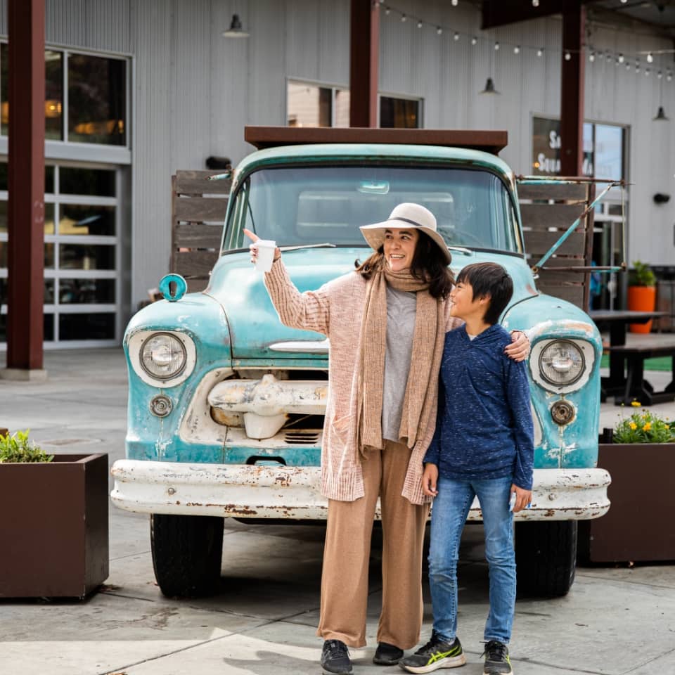 Woman with her son in front of a classic car