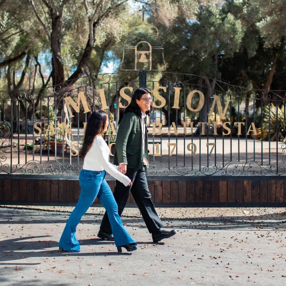 Man walking with his daughter in front of a mission